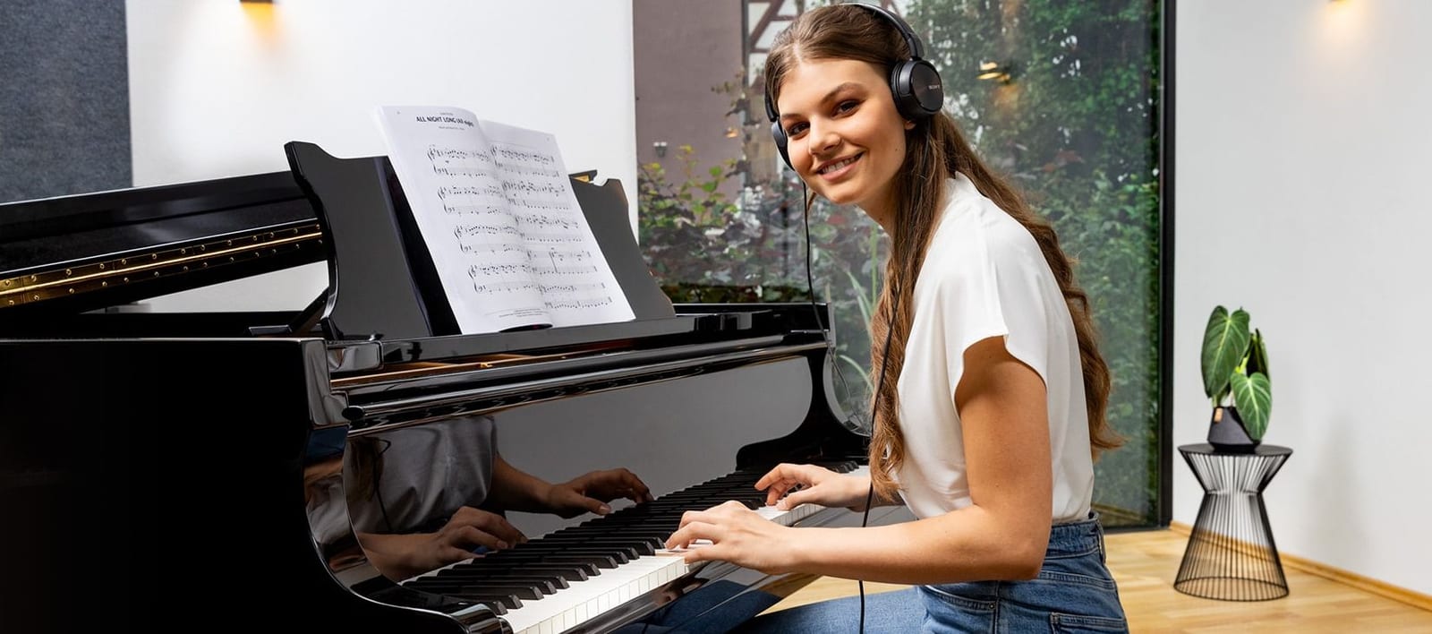 Jeune pianiste jouant au casque sur un piano équipé du système silencieux adsilent