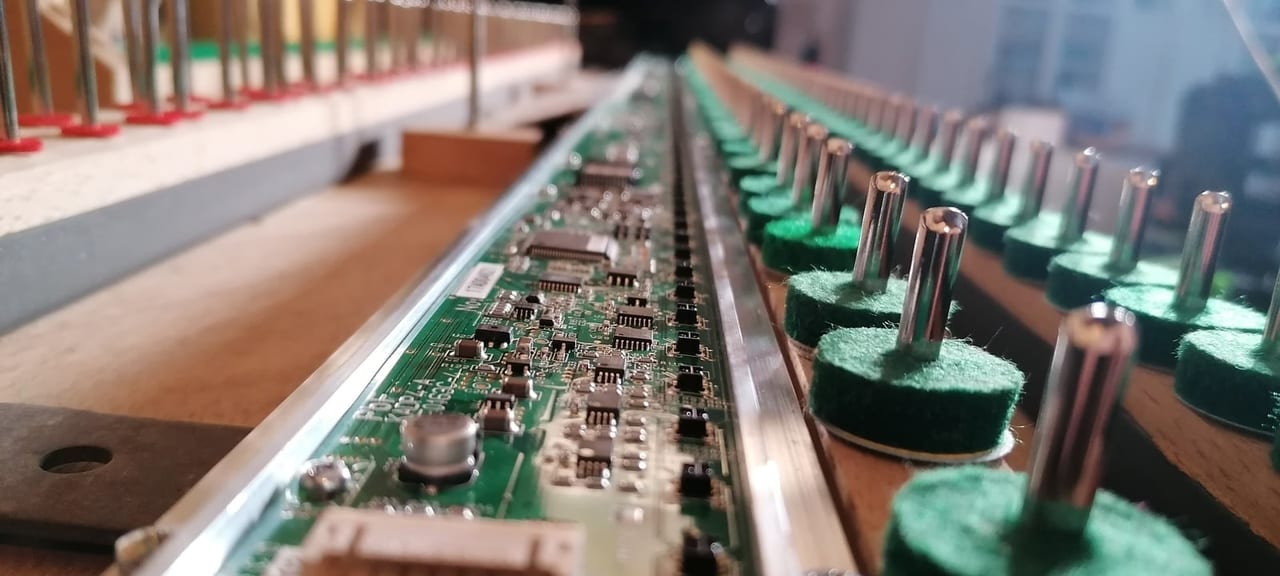 Rail de capteurs et barre d'arrêt adsilent installés sous le clavier d'un piano par Lorenz Piano